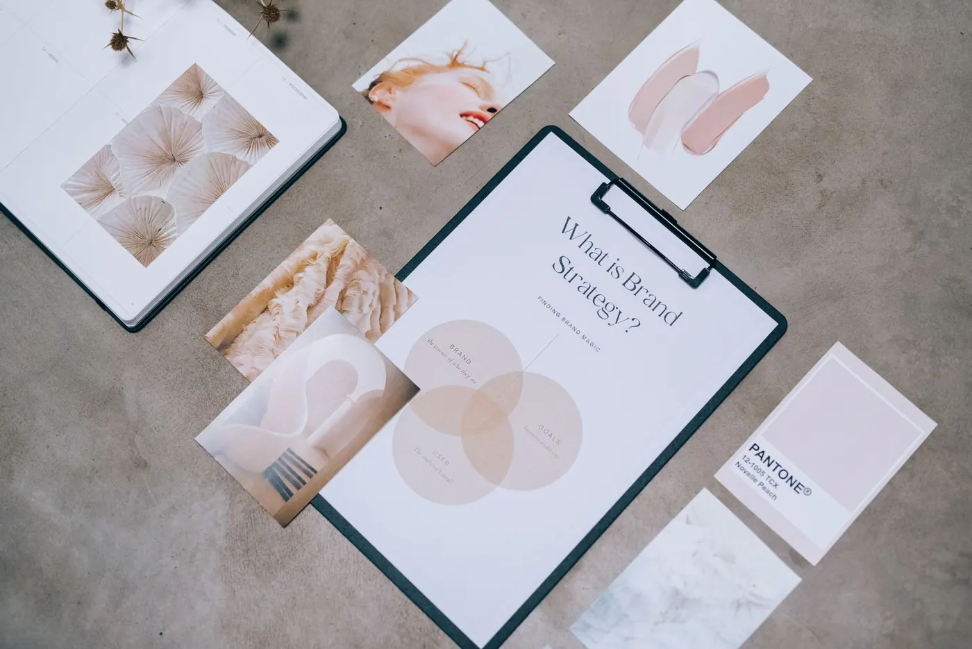 Materiais de identidade visual sobre a mesa: paleta, papelaria e estudo de marca