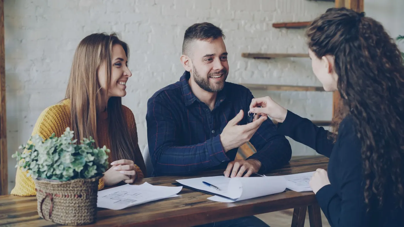 Atendimento comercial fechando negócio com um casal de clientes
