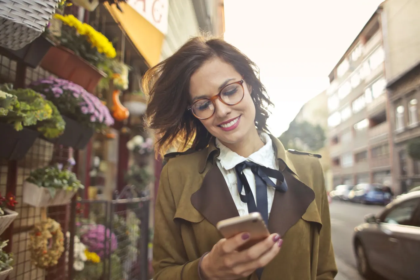 Mulher procurando um negócio no celular, na rua do bairro
