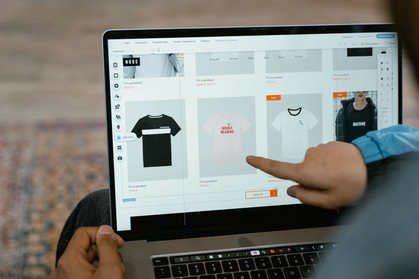 Dedo apontando produtos de uma loja virtual na tela do notebook